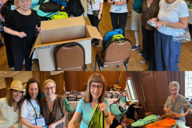 Members of the Temple Emanu-El community gather in a spacious, wood-paneled room as they joyfully assemble and pack colorful backpacks with school supplies, working together around tables filled with bags and materials for a mitzvah project.
