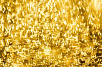 Abstract image of warm, golden lights with soft, glowing circles and ovals overlapping on a radiant yellow background, evoking a joyful and uplifting atmosphere reminiscent of festive celebrations.
