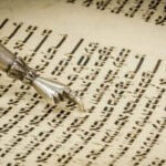 A close-up of a yad, a ritual pointer, guiding the reading of Hebrew text in a Torah scroll at Temple Emanu-El.