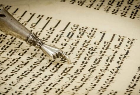 A close-up of a yad, a ritual pointer, guiding the reading of Hebrew text in a Torah scroll at Temple Emanu-El.