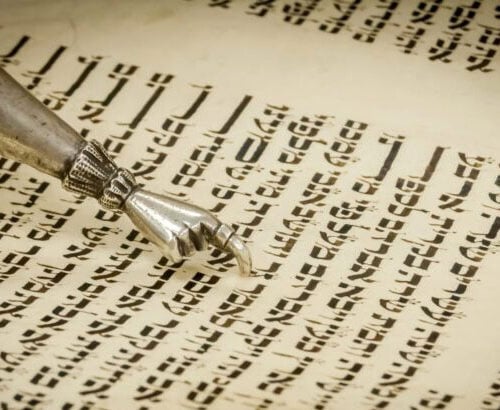 A close-up of a yad, a ritual pointer, guiding the reading of Hebrew text in a Torah scroll at Temple Emanu-El.