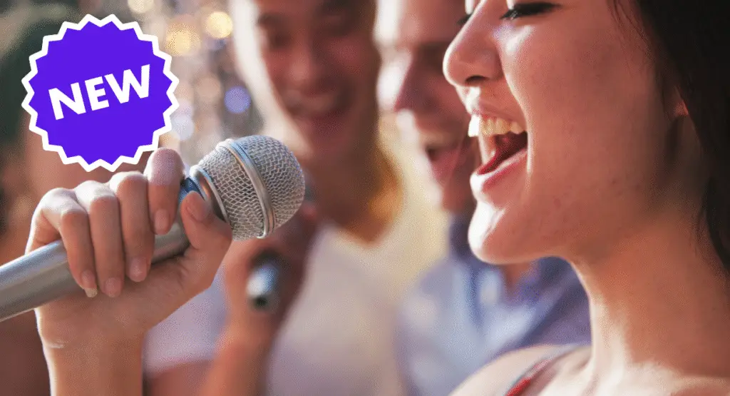 A woman joyfully singing into a microphone alongside friends, with a purple NEW badge nearby.