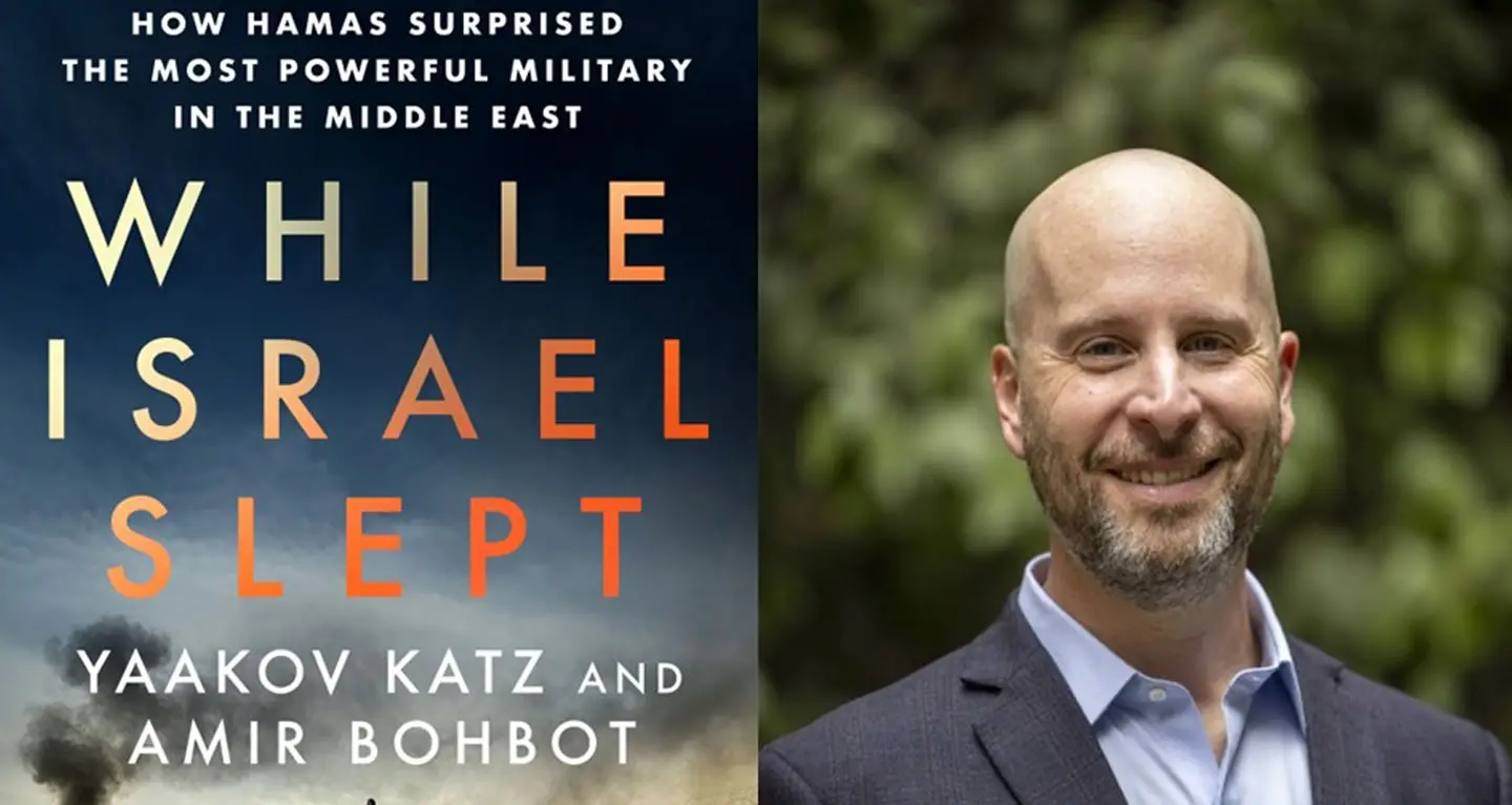 Book cover While Israel Slept on left; smiling man in a suit stands outdoors with green foliage in background, right.