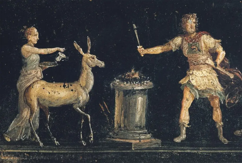 A woman leads a deer toward an altar as a man stands nearby; an offering burns atop the altar in a ceremonial scene.