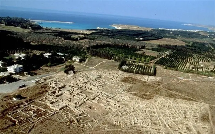 Aerial view of historic coastal ruins with trees and the sea, evoking connections to Jewish heritage and ancient traditions.