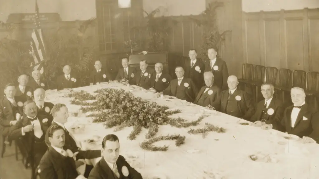 A group of people in formal attire gather around a beautifully decorated banquet table at Temple Emanu-El in New York City.