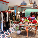 Elegant temple gift shop featuring Judaica items, floral displays, and tasteful decor on a checkered floor.