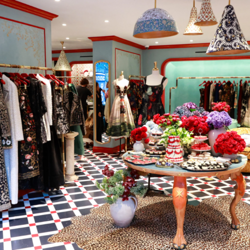 Elegant temple gift shop featuring Judaica items, floral displays, and tasteful decor on a checkered floor.