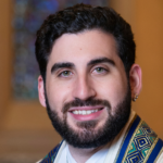 A portrait of a smiling rabbi wearing a tallit at Temple Emanu-El.
