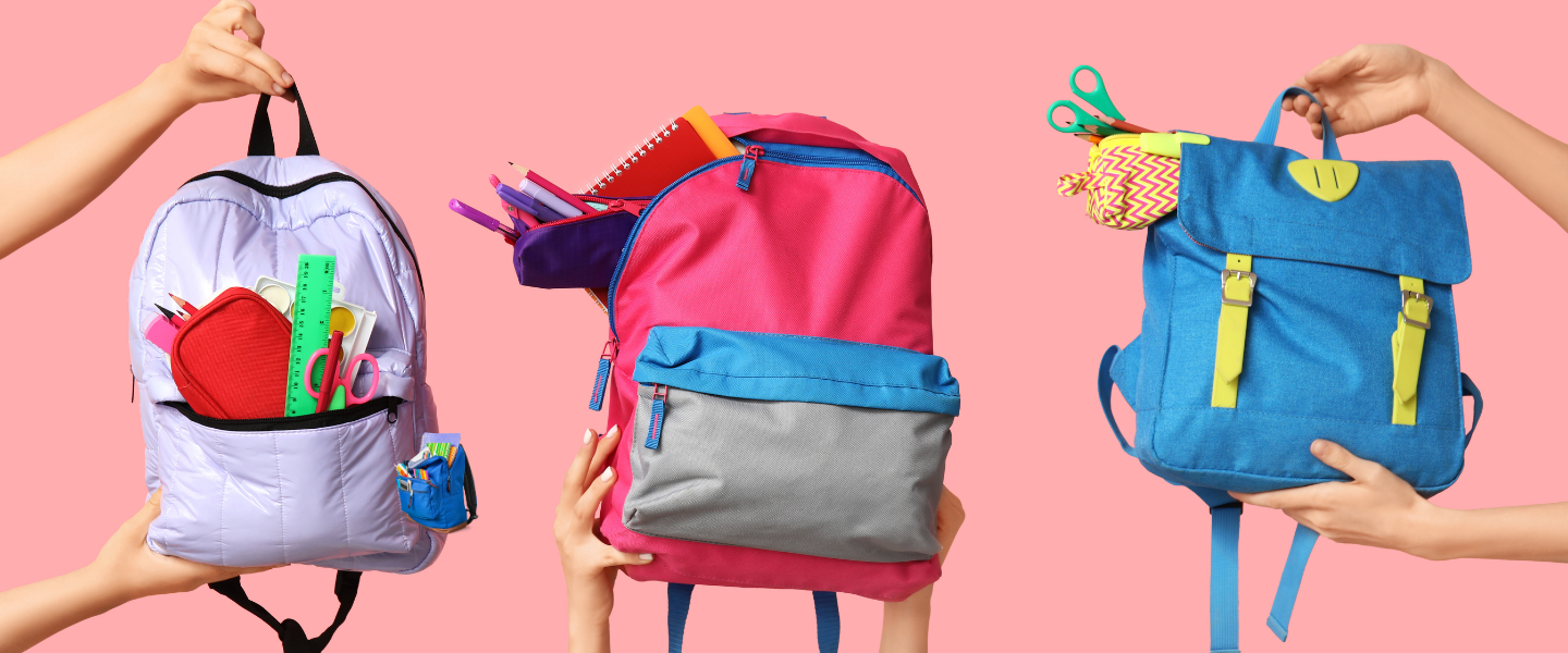 Three colorful backpacks held by hands, filled with school supplies, against a pink background, representing support for students through Temple Emanu-El’s community initiatives.