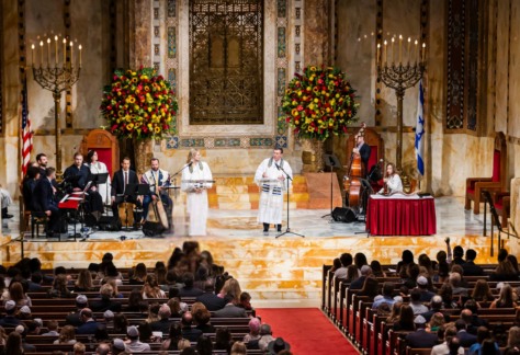 A choir and musicians perform for an audience during a ceremony in the majestic sanctuary of Temple Emanu-El in New York City.