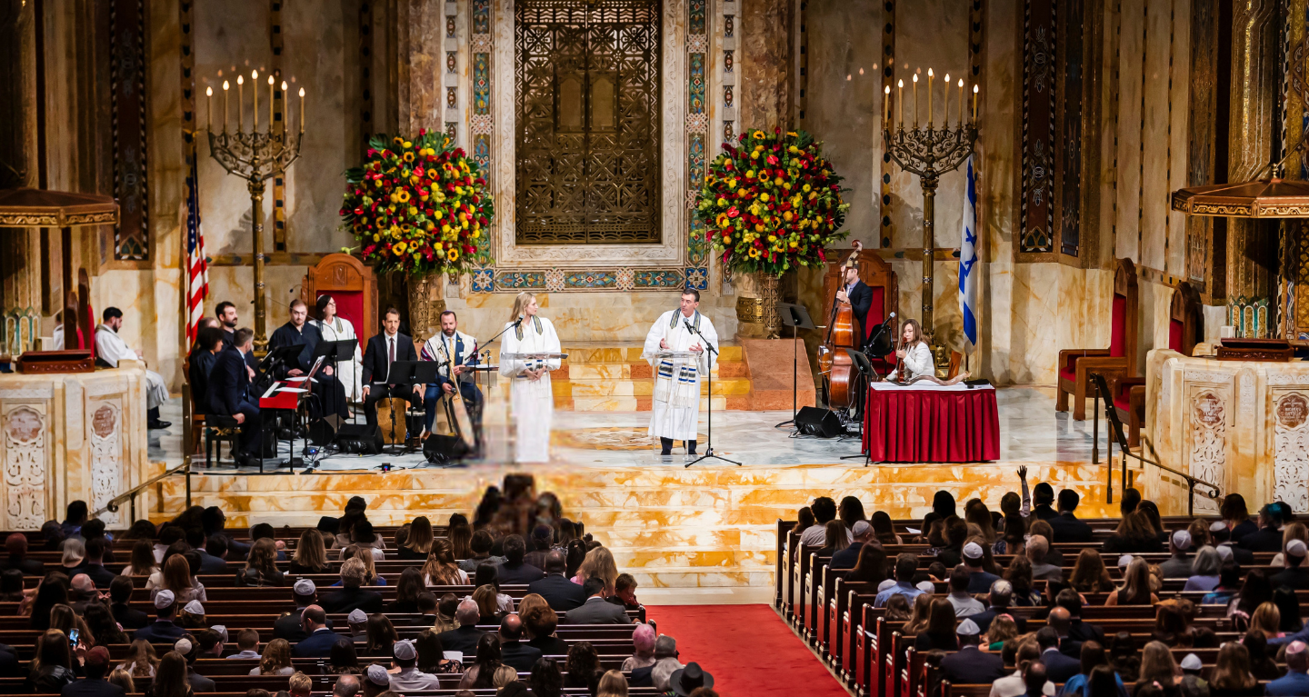 A choir and musicians perform for an audience during a ceremony in the majestic sanctuary of Temple Emanu-El in New York City.