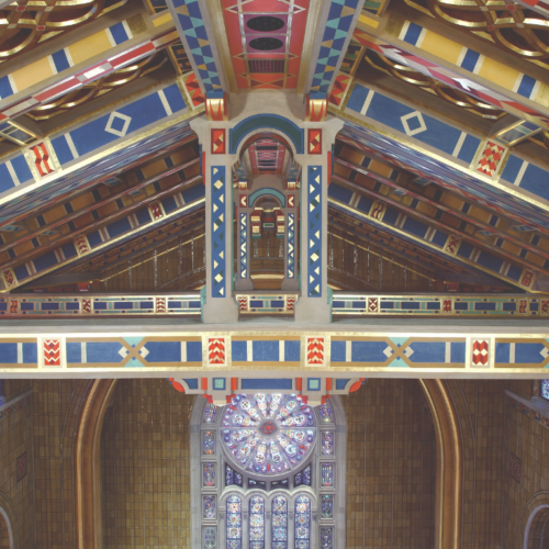 Colorful, ornate wooden ceiling and stained glass windows inside Temple Emanu-El, a major Reform Jewish synagogue in New York City.
