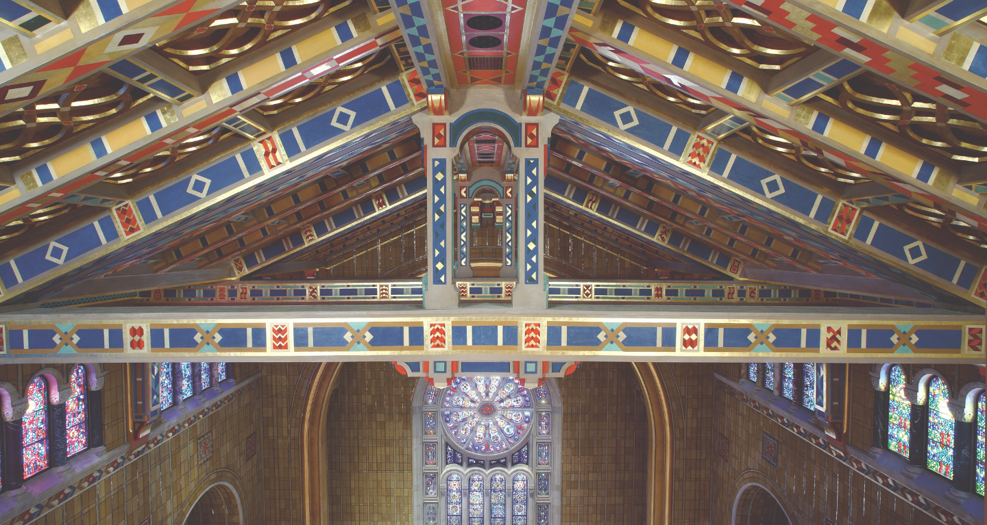 Colorful, ornate wooden ceiling and stained glass windows inside Temple Emanu-El, a major Reform Jewish synagogue in New York City.