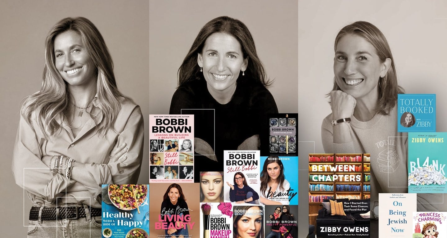 Three women smiling warmly at a book display table, each presenting their published works, with a blend of grayscale and color in the image.