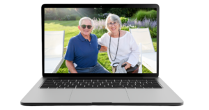 A laptop shows a smiling older couple, members of Temple Emanu-El, enjoying each other’s company while seated on patio chairs in a sunny garden.