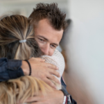 Two congregants share a warm embrace at Temple Emanu-El.