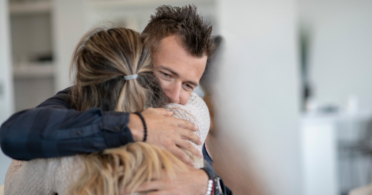 Two congregants share a warm embrace at Temple Emanu-El.