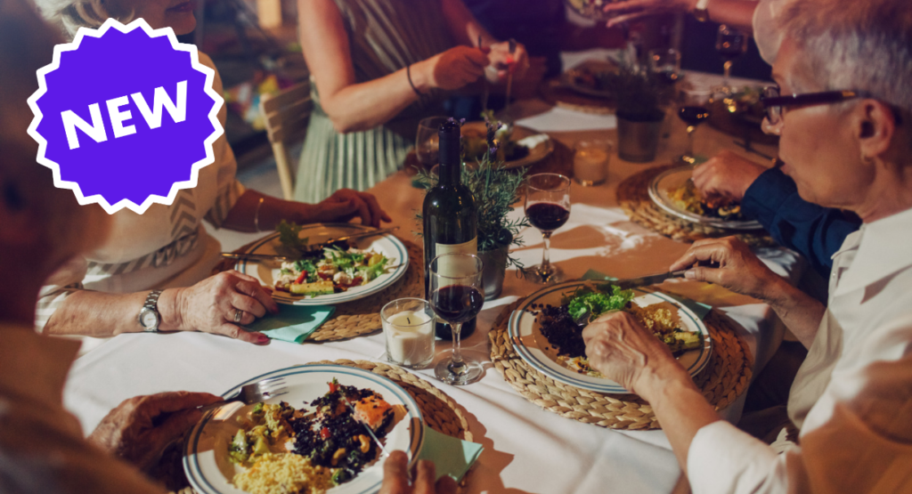 A community gathering for a meal at a table, featuring a NEW burst icon in the corner.