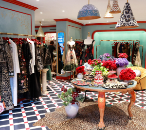 Elegant temple gift shop featuring Judaica items, floral displays, and tasteful decor on a checkered floor.