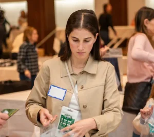 Temple Emanu-El members packing supplies into bags at a community service event, with tables and fellow volunteers in the background.