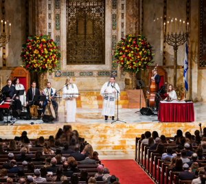 A choir and musicians perform for an audience during a ceremony in the majestic sanctuary of Temple Emanu-El in New York City.