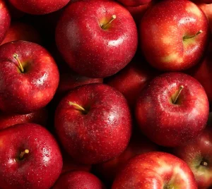 A close arrangement of fresh, glistening red apples, reminiscent of Rosh Hashanah traditions at Temple Emanu-El.