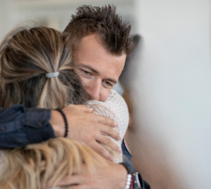 Two congregants share a warm embrace at Temple Emanu-El.