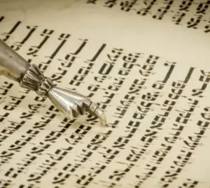 A close-up of a yad, a ritual pointer, guiding the reading of Hebrew text in a Torah scroll at Temple Emanu-El.